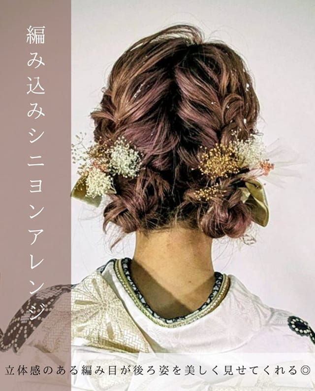 編み込みを組み合わせたシニヨンアレンジの、女性の後ろ姿が写っている