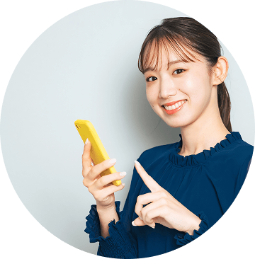 片手でスマホを操作しながら、笑顔でこちらを見ている